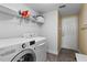 Laundry room featuring a washer, dryer, storage shelves, and direct access to the exterior at 644 Strihal Loop, Oakland, FL 34787