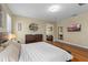 Bedroom featuring a decorative shelf, a dresser and mirror, and a comfortable bed with hardwood flooring at 644 Strihal Loop, Oakland, FL 34787