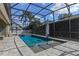 Beautiful screened pool area with stone pavers, lighting, and a lush tropical backdrop perfect for relaxing and entertaining at 644 Strihal Loop, Oakland, FL 34787