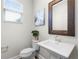 Bright powder room featuring a pedestal sink, decorative mirror, and window at 696 Orange Belt Loop, Winter Garden, FL 34787