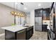 Modern kitchen featuring a large island with stainless steel sink, a large refrigerator, and dark wood cabinets at 696 Orange Belt Loop, Winter Garden, FL 34787