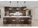 Spacious kitchen island features a white countertop, dark cabinets, and stylish pendant lighting at 7323 Sienna Wood Ave, Orlando, FL 32829