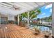 Covered back patio with a view of the in-ground pool, lake, and lush landscaping at 7496 Lake Marsha Dr, Orlando, FL 32819