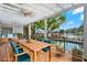 Outdoor patio with seating and dining under a pergola, overlooking the pool and lake at 7496 Lake Marsha Dr, Orlando, FL 32819