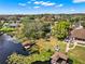 Lakeside backyard with lush greenery, private boat dock, and entertainment patio at 7496 Lake Marsha Dr, Orlando, FL 32819