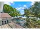 Scenic balcony view features a pool, lake, dock, and lush trees under a sunny sky at 7496 Lake Marsha Dr, Orlando, FL 32819