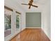 This bedroom features a set of french doors to a patio and hardwood floors at 7496 Lake Marsha Dr, Orlando, FL 32819