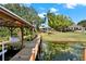 Private boat dock leads to lake with the home's manicured lawn visible in the background at 7496 Lake Marsha Dr, Orlando, FL 32819