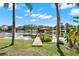 Lakeside view of a private wooden dock and gazebo surrounded by palm trees and a serene atmosphere at 7496 Lake Marsha Dr, Orlando, FL 32819