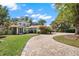 Charming home featuring a circular paver driveway and a lush, well-maintained front yard at 7496 Lake Marsha Dr, Orlando, FL 32819