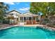 Large in-ground pool with brick-paver patio, with view of house and green lawn at 7496 Lake Marsha Dr, Orlando, FL 32819