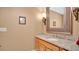 Bathroom with a granite vanity, framed mirror, and decorative lighting fixture at 7655 Debeaubien Dr, Orlando, FL 32835