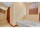 Bathroom featuring a jetted tub, wood cabinetry, and tile flooring at 7655 Debeaubien Dr, Orlando, FL 32835