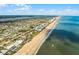 Expansive aerial view of a beachfront community featuring pristine sandy shores and oceanfront homes under a clear blue sky at 815 Ocean Shore Blvd # U7A, Ormond Beach, FL 32176