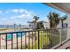 A balcony view highlights the pool, landscaping, and adjacent beach at 815 Ocean Shore Blvd # U7A, Ormond Beach, FL 32176