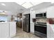 Well-lit kitchen equipped with stainless steel appliances and white cabinetry at 815 Ocean Shore Blvd # U7A, Ormond Beach, FL 32176