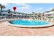 A beautiful pool in front of the condo complex, surrounded by chairs and palm trees with blue skies above at 815 Ocean Shore Blvd # U7A, Ormond Beach, FL 32176