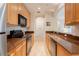 Efficient kitchen layout with wood cabinets, granite countertops, and modern appliances at 8168 Boat Hook Loop # 707, Windermere, FL 34786