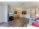 A cozy living room featuring wood floors, ceiling fan, TV, and view of dining room at 8168 Boat Hook Loop # 707, Windermere, FL 34786