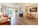 A cozy living room featuring a ceiling fan, an outside patio view and wood-style flooring at 8168 Boat Hook Loop # 707, Windermere, FL 34786