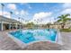 Large community pool with palm trees, lounge chairs, and a clubhouse under a sunny sky at 8168 Boat Hook Loop # 707, Windermere, FL 34786