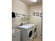 This laundry room features a sink, storage shelf, wall art, and a Whirlpool washer and dryer at 8237 Serenity Spring Dr # 2605, Windermere, FL 34786