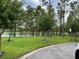 Scenic view of community pond surrounded by lush green trees and well-maintained landscaping at 8237 Serenity Spring Dr # 2605, Windermere, FL 34786