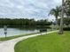 Beautiful view of a tranquil pond with a bench, surrounded by green grass and mature trees at 8237 Serenity Spring Dr # 2605, Windermere, FL 34786