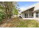 The backyard features a screened-in porch, trees, landscaping and white picket fence at 832 Westshore Ct, Casselberry, FL 32707