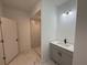 Bathroom featuring tile flooring, vanity and a walk-in shower with white-tiled walls at 1012 India Ave, Haines City, FL 33844