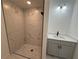 Modern bathroom with a spacious shower featuring elegant marble tile and a gray vanity at 1012 India Ave, Haines City, FL 33844