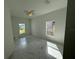 Bedroom with white walls, ceiling fan, large windows, and marble-style flooring at 1012 India Ave, Haines City, FL 33844