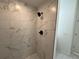 Updated shower with white marble tile surround and modern black shower head at 1012 India Ave, Haines City, FL 33844