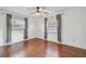 Bright bedroom featuring hardwood floors, a ceiling fan, and dual windows with shades at 104 E Cottesmore Cir, Longwood, FL 32779