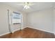 Cozy bedroom featuring hardwood floors, a ceiling fan, and a window with white curtains at 104 E Cottesmore Cir, Longwood, FL 32779