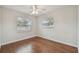 Bright bedroom with hardwood floors and natural light streaming through two large windows at 104 E Cottesmore Cir, Longwood, FL 32779