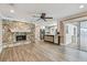 Open concept living room featuring stone fireplace, ceiling fan and luxury vinyl flooring at 104 E Cottesmore Cir, Longwood, FL 32779