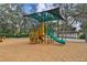 Community playground featuring a slide, climbing structures, and a shaded canopy at 104 E Cottesmore Cir, Longwood, FL 32779