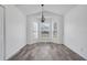 Bright dining area featuring wood-look tile floors, a modern chandelier, and a bay window with natural light at 1047 Bluegrass Dr, Groveland, FL 34736