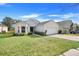 Inviting single-story home with lush green lawn and well-maintained shrubbery, showing curb appeal at 1047 Bluegrass Dr, Groveland, FL 34736