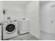 Bright laundry room with new washer and dryer and wire shelving for storage at 1047 Bluegrass Dr, Groveland, FL 34736