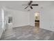 Open-concept living room with wood-look tile flooring, offering seamless transitions to other areas of the house at 1047 Bluegrass Dr, Groveland, FL 34736