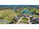 Aerial view of community golf course and clubhouse surrounded by ponds and greenery at 10509 Belfry Cir, Orlando, FL 32832