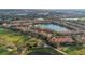 An aerial view of a community with townhomes situated among ponds, a golf course, and other green spaces at 10509 Belfry Cir, Orlando, FL 32832