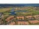 An aerial view showcases a golf course community with townhomes, ponds, and mature trees at 10509 Belfry Cir, Orlando, FL 32832