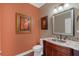 Elegant powder room featuring a decorative mirror, granite countertop, and warm lighting at 10509 Belfry Cir, Orlando, FL 32832