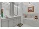 Bright bathroom featuring dual sinks, tub, vanity, and a gorgeous chandelier at 10509 Belfry Cir, Orlando, FL 32832