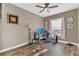 Neutral-toned bedroom features a ceiling fan, wood floors, and a window with pink drapes at 10509 Belfry Cir, Orlando, FL 32832