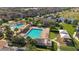 Aerial view of a resort-style community pool area with palm trees, lounge chairs, and a playground at 10509 Belfry Cir, Orlando, FL 32832