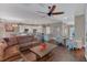 Open concept living room with wood floors, comfortable seating, and a modern ceiling fan at 10509 Belfry Cir, Orlando, FL 32832